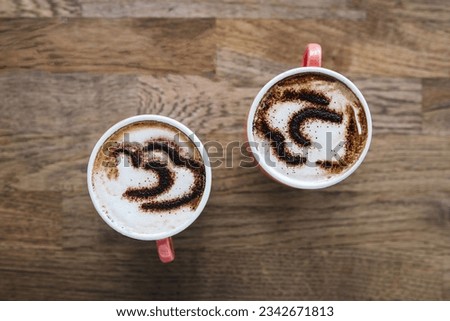 overhead shot of Two cups with coffee on wooden table