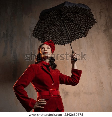 A stylish lady in a red old-fashioned suit with a hat and a lace umbrella Royalty-Free Stock Photo #2342680875