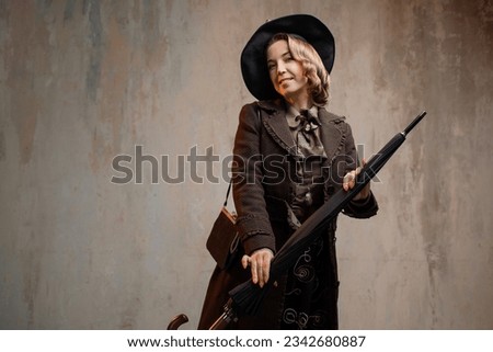 A stylish lady in an elegant Victorian-style suit, wearing a hat with an umbrella in her hands Royalty-Free Stock Photo #2342680887