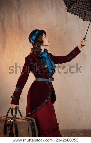 Mary Poppins. A stylish lady in a burgundy old - fashioned suit with a hat and a lace umbrella . Brunette in a retro style suit Royalty-Free Stock Photo #2342680955