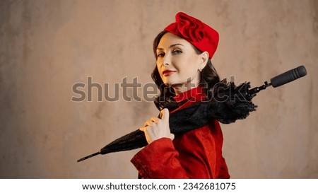 A stylish lady in a red old-fashioned suit with a hat and a lace umbrella Royalty-Free Stock Photo #2342681075