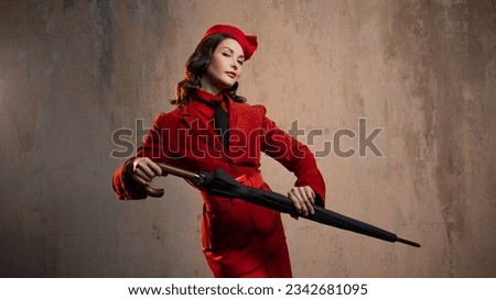 A stylish lady in a red old-fashioned suit with a hat and a lace umbrella Royalty-Free Stock Photo #2342681095