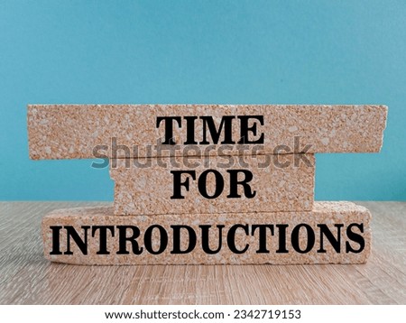 Time For Introductions write on brick blocks. Beautiful wooden table, blue background.