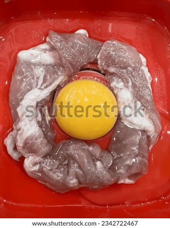 a photography of a red bowl with a yellow egg in it, there is a yellow egg in a red bowl with ice.