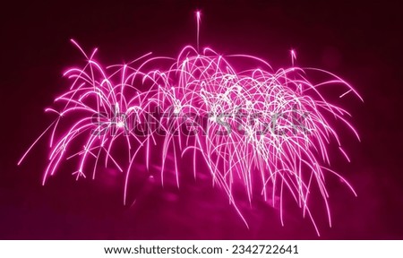 a photography of a pink fireworks is lit up in the dark, fireworks in the sky with pink lights and a black background.