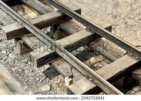 a photography of a train track with a broken rail, there is a close up of a train track with a broken rail.