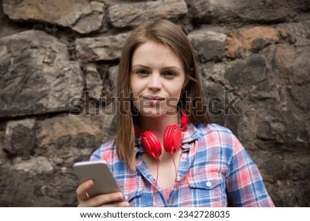 Portrait of a Young fashionable woman using a Smart Phone device.