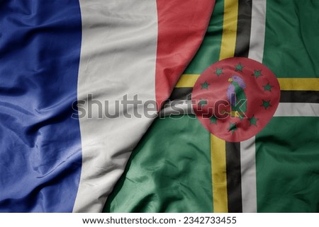 big waving realistic national colorful flag of france and national flag of dominica . macro