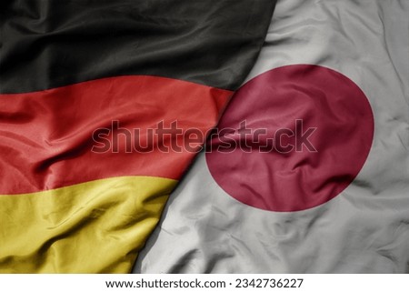 big waving realistic national colorful flag of germany and national flag of japan . macro