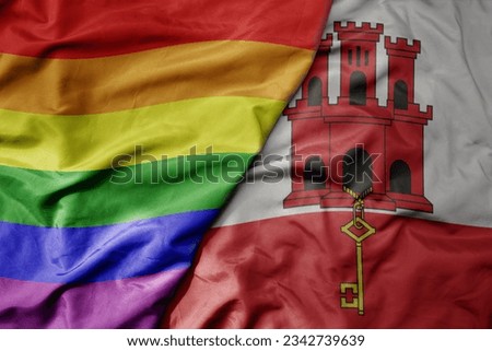 big waving realistic national colorful flag of gibraltar and rainbow gay pride flag . macro