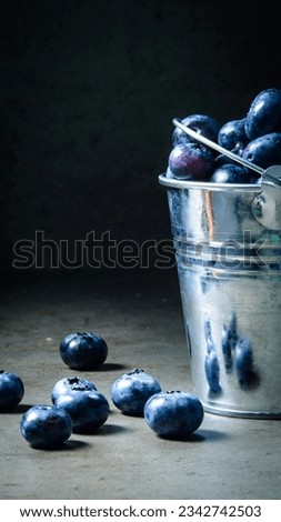 Still life with blueberries and a bucket. Dark style