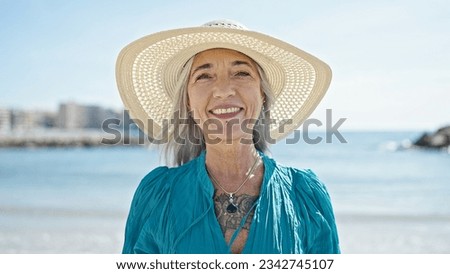Middle age grey-haired woman tourist smiling confident standing at beach Royalty-Free Stock Photo #2342745107
