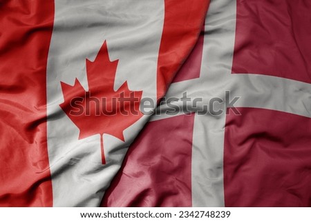 big waving realistic national colorful flag of canada and national flag of denmark . macro