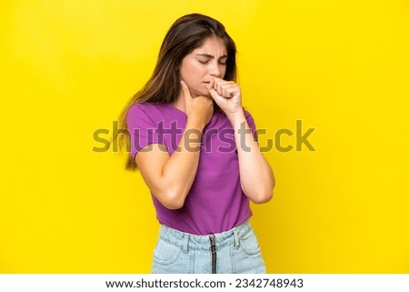 Young caucasian woman isolated on yellow background coughing a lot