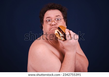 Funny hungry fat man eating burger.