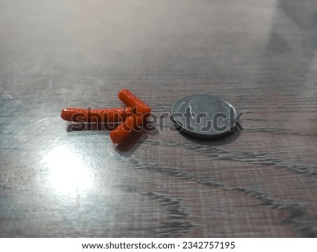 
Arrow snack pointing to a dollar coin lying on a wooden table.