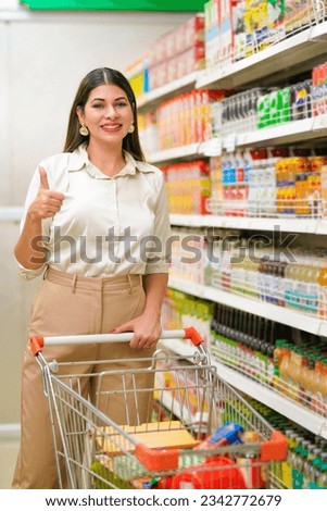 Indian woman showing thumps up while shopping at grocery shop.