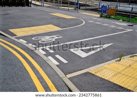 City street with road markings, signage, and pedestrian crossing symbol. No people in sight.