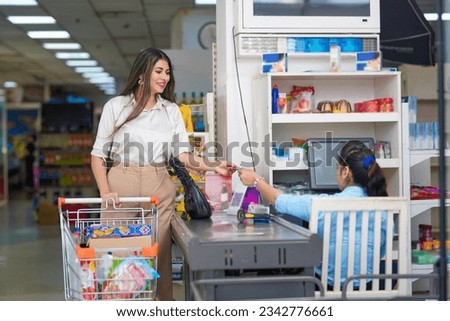 woman doing payment with card after shopping at supermarket. digital payment concept. Royalty-Free Stock Photo #2342776661