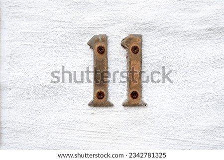 Number eleven made by brass on white background, concept idea for door number or ranking or sort number, close up