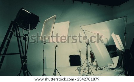 Silhouette of video production behind the scenes or B roll or making of TV commercial movie that film crew team lightman and cameraman working together with director in big studio with pro equipments