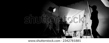 Silhouette of video production behind the scenes or B roll or making of TV commercial movie that film crew team lightman and cameraman working together with director in big studio with pro equipments Royalty-Free Stock Photo #2342781881