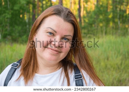 Close up portrait of a happy woman in the park on a warm sunny day.