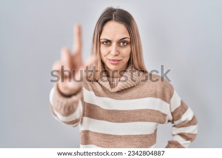 Young blonde woman wearing turtleneck sweater over isolated background pointing with finger up and angry expression, showing no gesture  Royalty-Free Stock Photo #2342804887