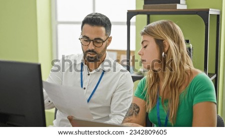Man and woman business workers using laptop reading document at office