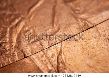 Extreme closeup of crumpled brass foil texture. Selective soft focus, shallow depth of field.