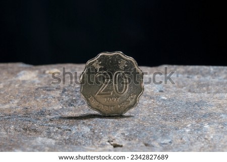 A closeup of  a silver 1 dollar on the rocky surface with a dark background