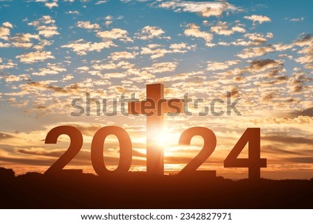 Silhouette of Christian cross with 2024 years at sunset background. Concept of Christians new year 2024