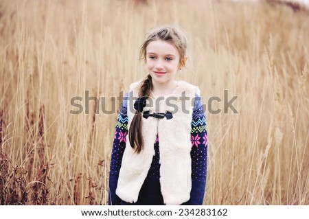 Adorable little girl in warm clothes, autumn time