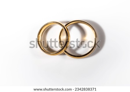 Two shining gold wedding rings isolated on white background, symbolizing the bond of marriage and everlasting love