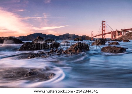 A mesmerizing time lapse image of a river flowing through a cityscape with the iconic Golden Gate Bridge in the background