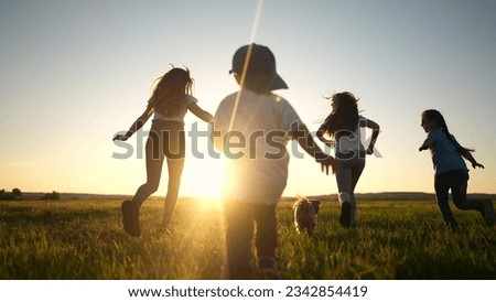 happy family. people in the park. children child running together in the park on grass silhouette. daughter and son are running. happy family and little child in summer. concept sunset dream Royalty-Free Stock Photo #2342854419