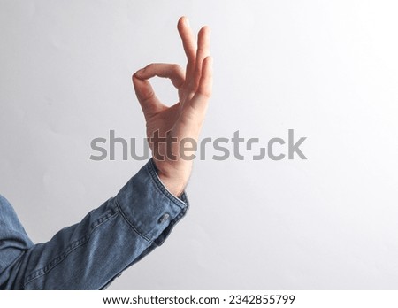 Man's hand in a denim shirt shows a zen symbol on a gray background. Overcome stress. business concept