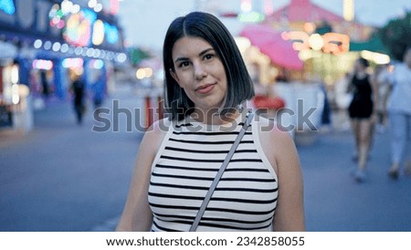 Young beautiful hispanic woman smiling looking around at Prater Vienna