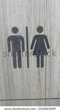Man and woman icons etched in a door at public toilet.