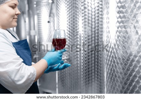 Quality control drink on brewery industry factory, Worker takes sample of mead beer in wineglass from tanker.