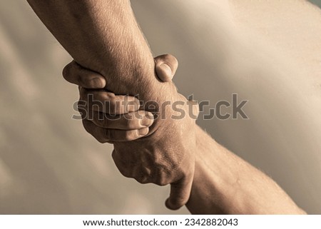Rescue, helping gesture or hands. Two hands, helping arm of a friend teamwork. Helping hand outstretched, arm, salvation. Royalty-Free Stock Photo #2342882043