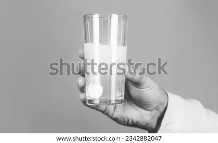 White pill and a glass of water in man hands. Health concept. Close up of man holding a pill.