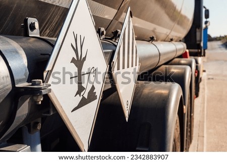 Danger labels on a tanker truck for dangerous goods, indicative of various hazards and land and sea pollution according . Royalty-Free Stock Photo #2342883907