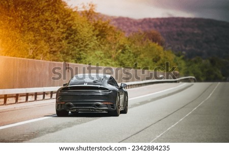 Sleek Black German Roadster. Brand New Luxury Carrera Sports Car on the Highway. Rear view of the 911 GTS sports car. Royalty-Free Stock Photo #2342884235