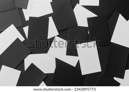 Top view mockup of white and black horizontal business cards scattered at black textured paper background.