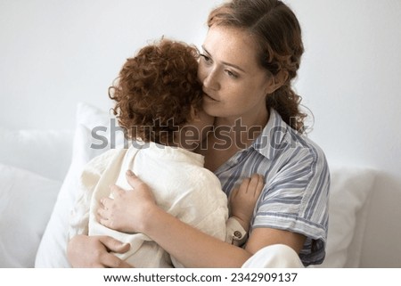 Caring young mom comforting crying toddler child, hugging little kid, holding in arms, giving support, love. Mother embracing little kid, enjoying motherhood, parenthood Royalty-Free Stock Photo #2342909137