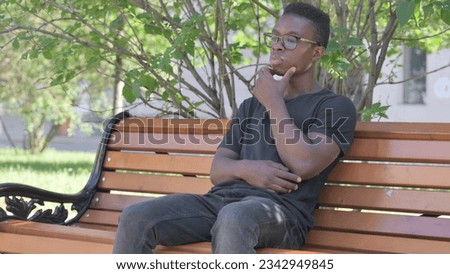 Brainstorming Young African Man Sitting Outdoor