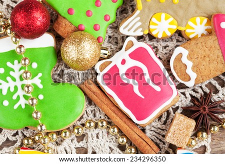 Homemade christmas painted gingerbreads (gift, boot, locomotive) on the wooden background with Christmas decorations. Selective focus and place for text. Toned