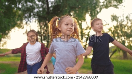 children in the park. boys and girls run through the green park laughing. spending time with friends. happy family lifestyle kids dream concept