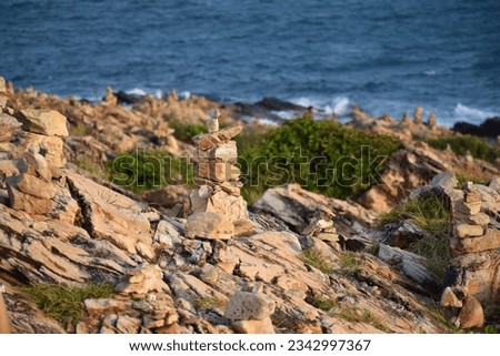 Natural texture : Photography of mystical stone piles and figures left by tourists on the rocks,Rock, stone, textured. Background for design.folded pyramid of smooth stones on the seashore.
